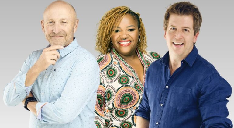 Hot Breakfast team stand smiling in front of a gray gradient background, as if ready to enjoy a Hot Breakfast: a bald man in a light blue shirt on the left, a woman with blonde braids and a patterned shirt in the center, and a man in navy blue on the right.