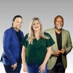 Three adults stand side by side, smiling with drive against a gray background. The person on the left wears a blue blazer, the center person has long blonde hair and a green shirt, and the person on the right wears a green jacket.