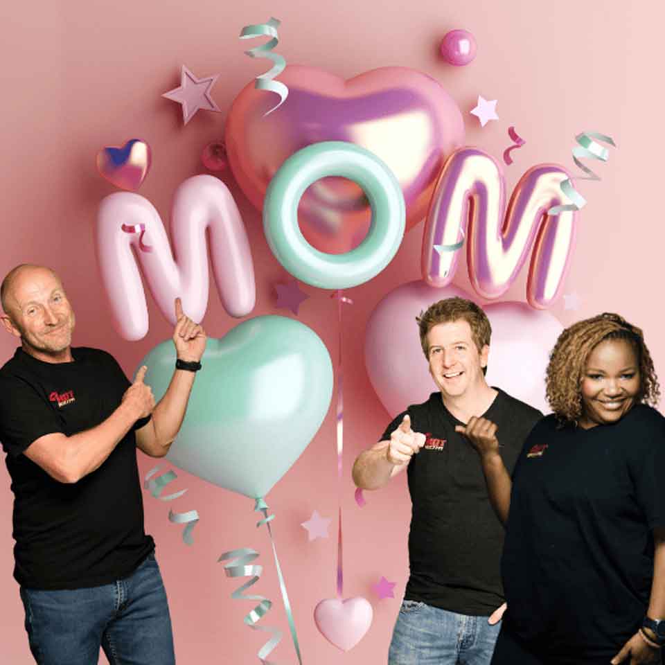 Three smiling people stand in front of pastel heart and letter balloons spelling MOM on a pink background with stars and ribbon decorations.