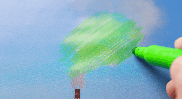 A hand uses a green marker to draw over smoke coming from a factory chimney, making it look like tree foliage against a blue sky.