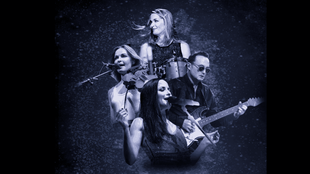 Four musicians perform on stage, reminiscent of The Corrs: three women singing while playing violin, drums, and guitar, with a man on electric guitar—all set against a starry, dark blue background.