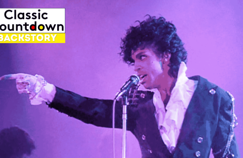 A musician in a ruffled white shirt and dark jacket sings into a microphone on a purple-lit stage, channeling Prince vibes as he points outward. The Classic Countdown Backstory logo appears in the top left corner.