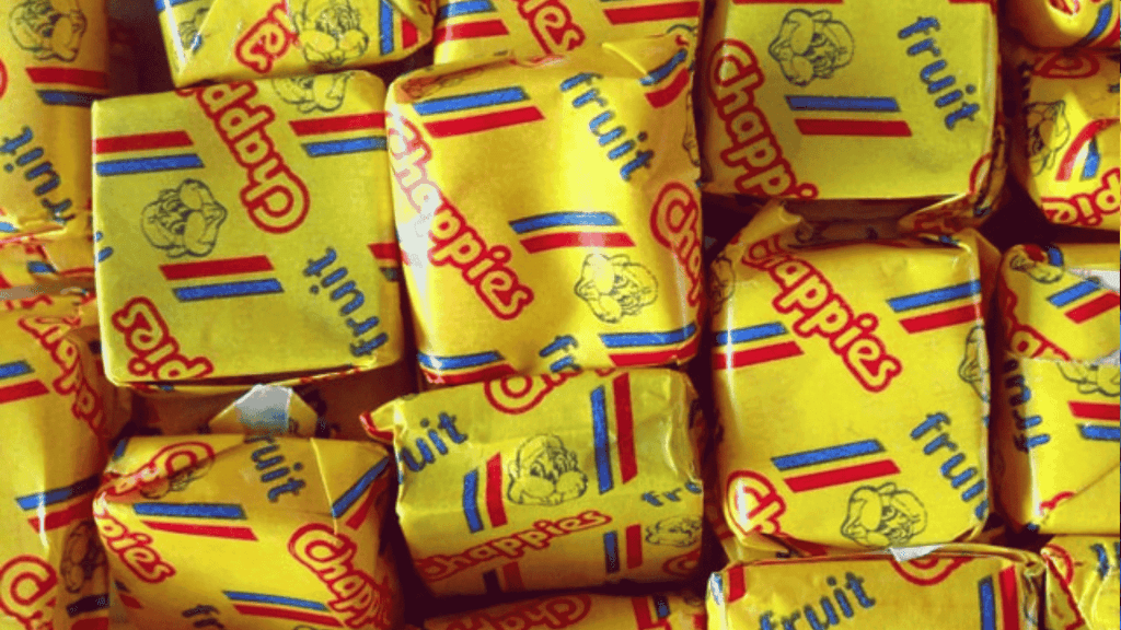 A close-up of several yellow-wrapped Chappies fruit-flavored bubblegum pieces, with colorful red and blue stripes and the Chappies logo printed on the wrappers—classic treats that have sparked fun and unique business opportunities.