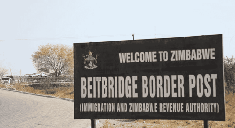 A large sign reads “Welcome to Zimbabwe. Beitbridge Border Post (Immigration and Zimbabwe Revenue Authority)” next to a paved road, with trees and dry grass in the background, highlighting potential business opportunities at this busy crossing.