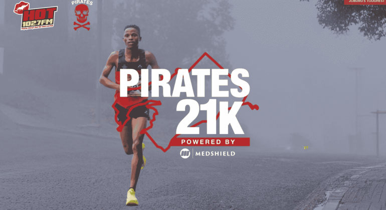 A male runner in athletic gear runs on a misty road. Bold text reads PIRATES 21K Powered by Medshield. Logos for HOT 102.7FM, Die Kantoor, and Pirates are visible, with a faint cityscape in the background.