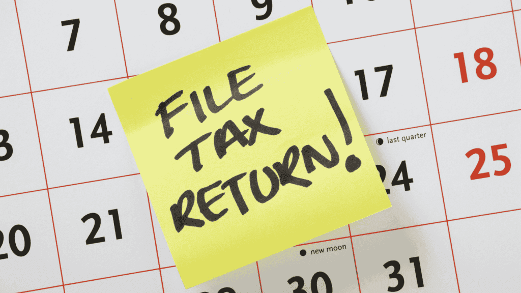 A yellow sticky note with FILE TAX RETURN! written in bold black letters is placed on a calendar, serving as an important reminder for Matric students to stay organized and meet their deadlines.
