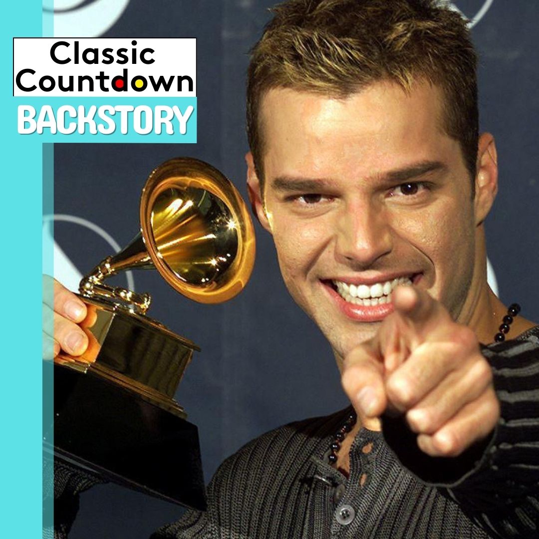 A smiling man holding a Grammy award points toward the camera, capturing the excitement of a "Last Christmas" celebration. The image features a Classic Countdown BACKSTORY logo in the top left corner with a turquoise background.