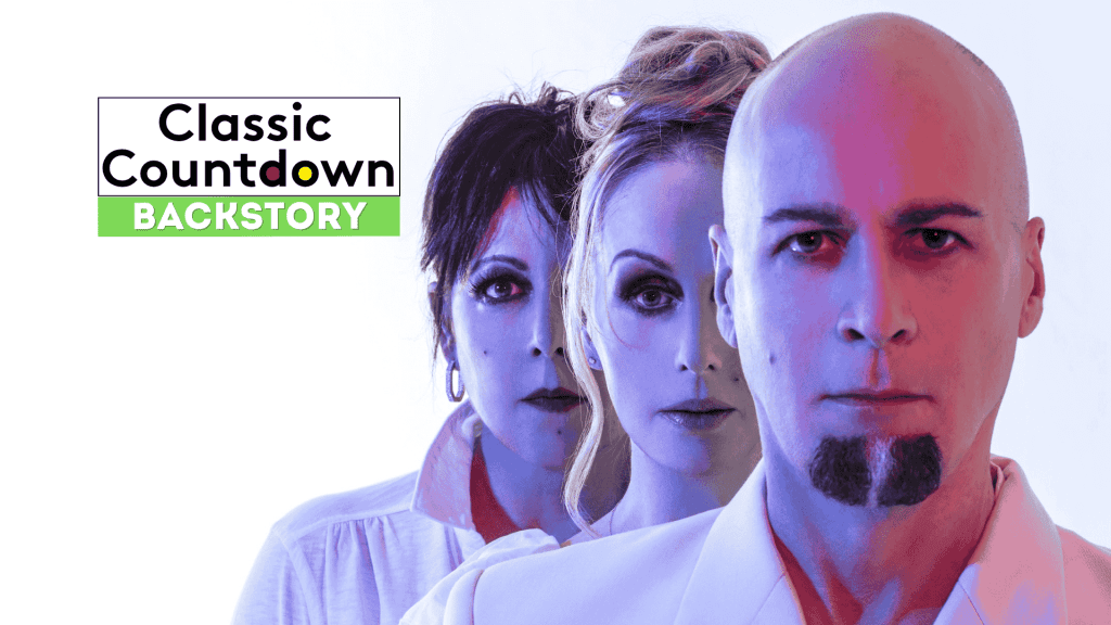 Three people stand in a line with serious expressions, facing forward. Text on the left reads, Classic Countdown Backstory with Backstory highlighted in green. The image has a blue and pink color tone.