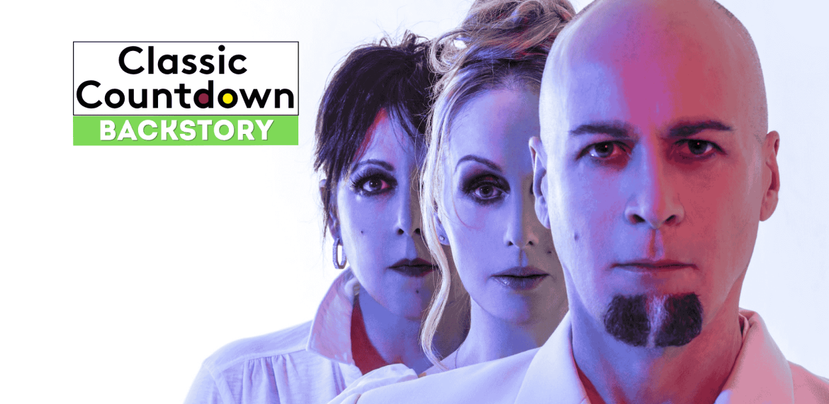 Three people stand in a line with serious expressions, facing forward. Text on the left reads, Classic Countdown Backstory with Backstory highlighted in green. The image has a blue and pink color tone.