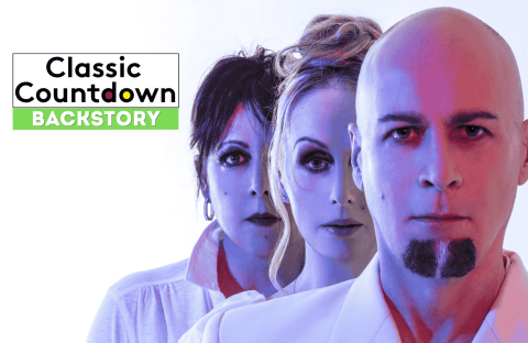 Three people stand in a line with serious expressions, facing forward. Text on the left reads, Classic Countdown Backstory with Backstory highlighted in green. The image has a blue and pink color tone.