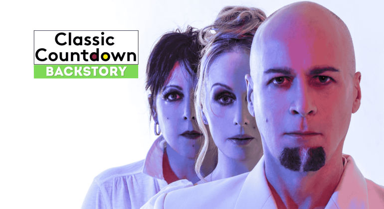Three people stand in a line with serious expressions, facing forward. Text on the left reads, Classic Countdown Backstory with Backstory highlighted in green. The image has a blue and pink color tone.