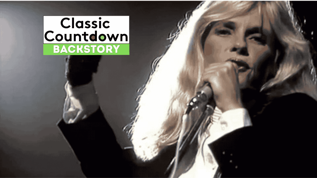 A performer with long blond hair sings into a microphone on stage. The image features the text Classic Countdown Backstory in the top left corner.