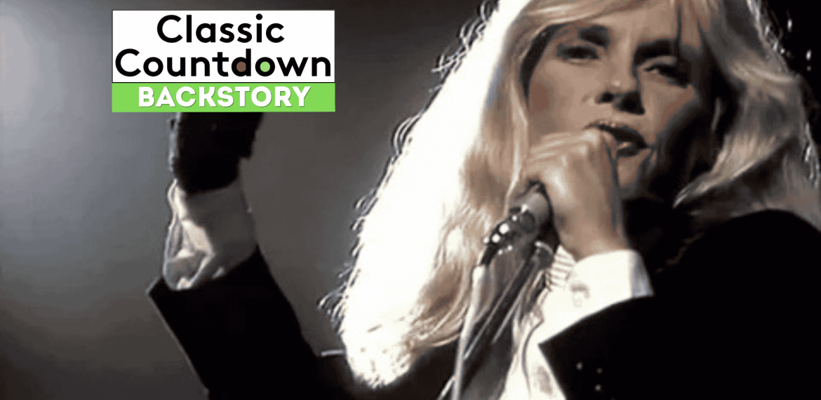 A performer with long blond hair sings into a microphone on stage. The image features the text Classic Countdown Backstory in the top left corner.