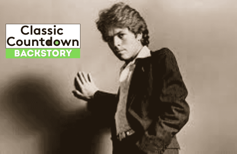 A young man in a suit poses with one hand pressed against a wall. The words Classic Countdown Backstory appear in bold text, with Backstory highlighted in green on the left side of the image.
