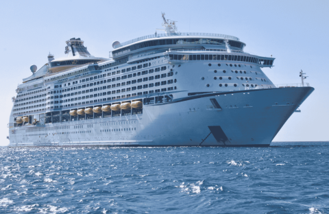 A large white cruise ship, reminiscent of the grandeur seen in Lloyd Madurai’s fleet, floats on calm blue ocean water under a clear sky, viewed from a low angle near the front of the vessel.