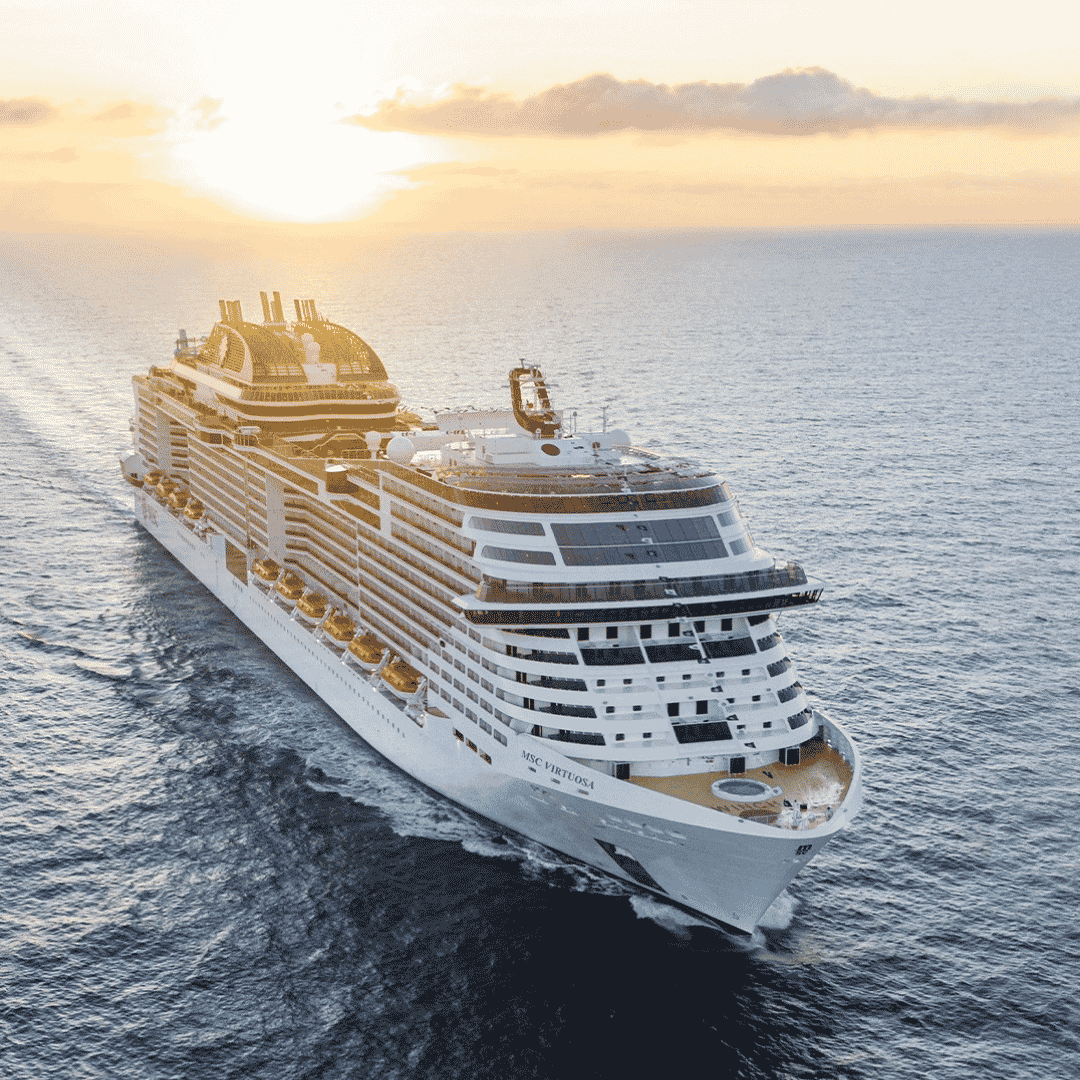 A large white cruise ship, reminiscent of the elegance found on Lloyd Madurai voyages, sails on calm ocean waters at sunset, with the sun partially hidden by clouds in the background. The ship creates gentle waves as it moves forward.