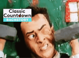 A clay animation character with an exaggerated facial expression lifts two gray dumbbells in front of a green background and a red window, channeling Robert Palmer style. Text on the image reads Classic Countdown Backstory.