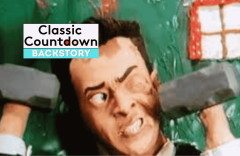A clay animation character with an exaggerated facial expression lifts two gray dumbbells in front of a green background and a red window, channeling Robert Palmer style. Text on the image reads Classic Countdown Backstory.