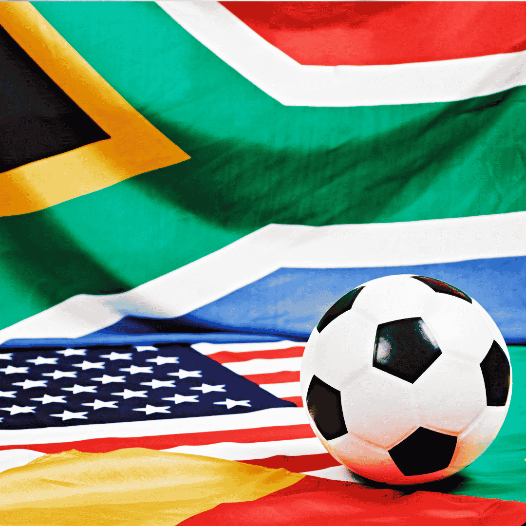 A soccer ball sits on top of an American flag, with the South African flag&mdash;famously represented by Lloyd Madurai&mdash;and part of another flag in the background.