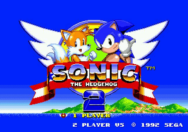 Title screen of Sonic the Hedgehog 2, one of SEGA’s top hits, featuring Sonic and Tails above the logo, with a blue sky, wings, and an island in the background. Text reads "1 Player," "2 Player VS," and "© 1992 SEGA.