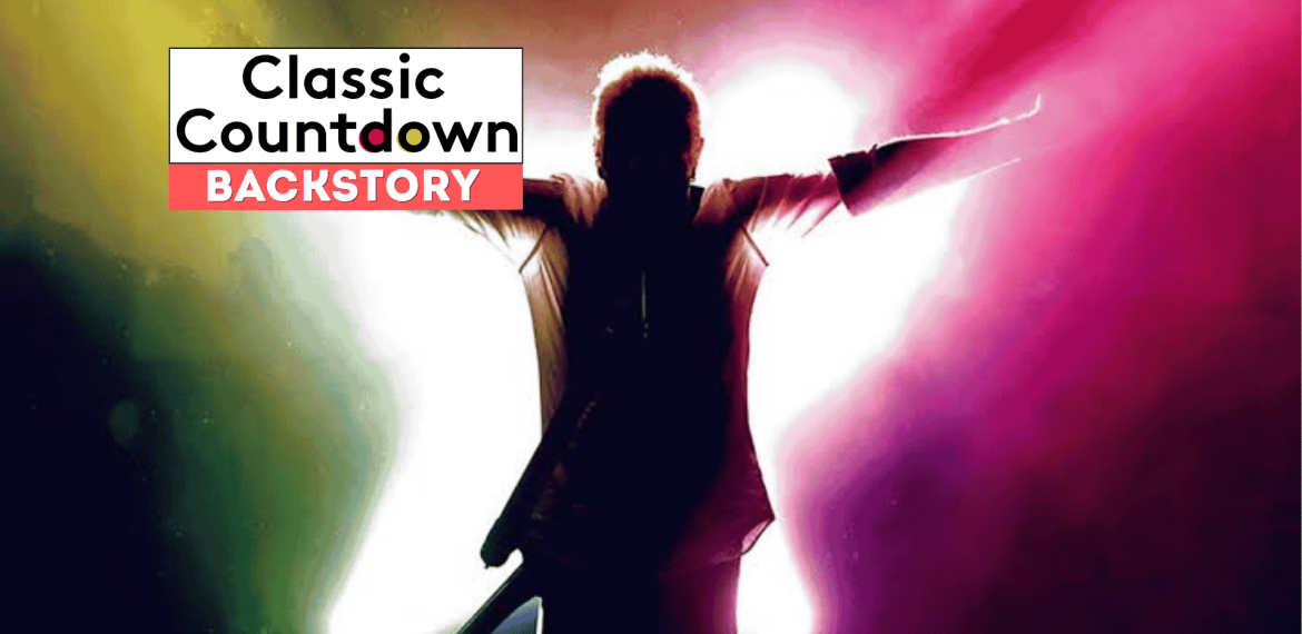A person stands with arms outstretched in front of a bright, colorful background. The text Classic Countdown BACKSTORY appears in the top left corner, offering a glimpse into the backstory of icons like Robert Palmer.