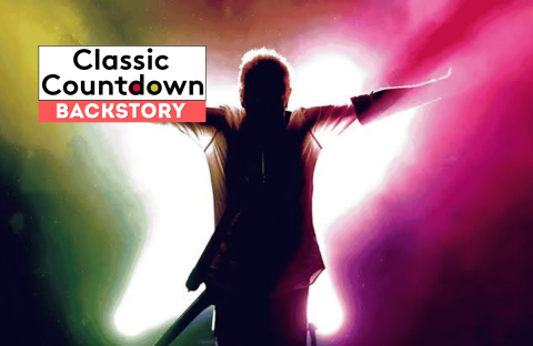 A person stands with arms outstretched in front of a bright, colorful background. The text Classic Countdown BACKSTORY appears in the top left corner, offering a glimpse into the backstory of icons like Robert Palmer.
