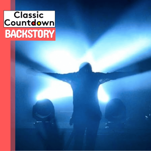 A person stands on stage with arms outstretched, silhouetted by bright blue lights. The Backstory logo appears in the top left corner against a red and white background, capturing the dramatic style of Robert Palmer performances.