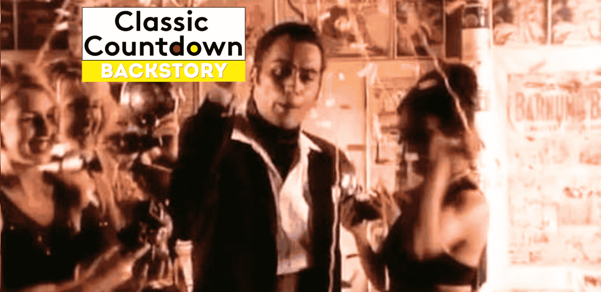 A man in a suit, reminiscent of Robert Palmer, stands in the center, surrounded by women with confetti falling. The words Classic Countdown Backstory appear in a bold white and yellow box at the top left.