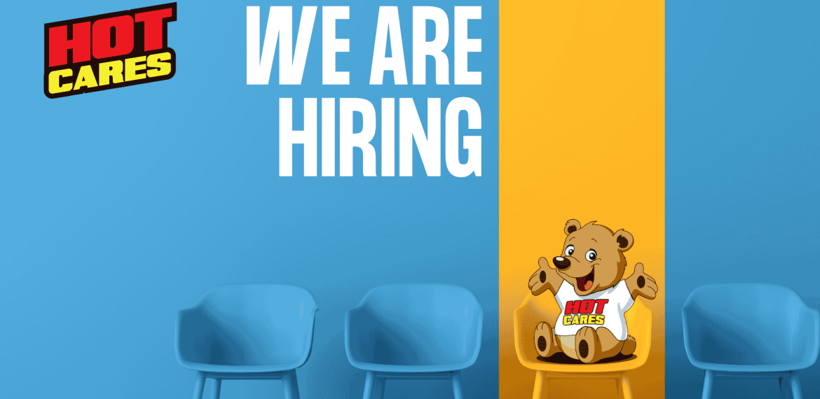 Blue chairs against a blue and yellow wall set the scene, with &ldquo;We Are Hiring&rdquo; written in large white text. A cartoon bear wearing a Hot Cares shirt sits on a yellow chair, inviting applicants to join our caring team. The Hot Cares logo appears in the top left corner as we continue our mission to support important causes like Shona breast cancer awareness.