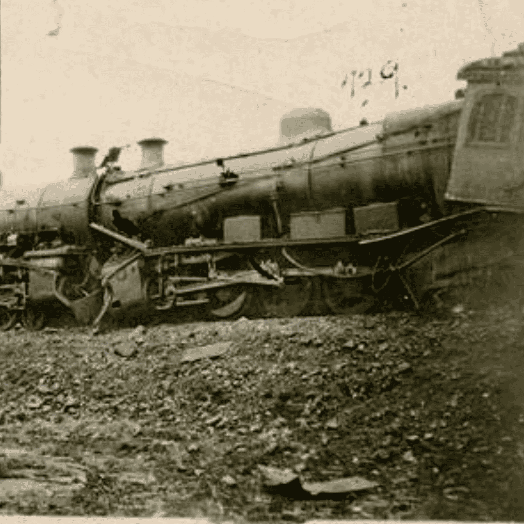 Black and white photo of a derailed steam locomotive leaning to one side, damaged and surrounded by debris on the ground, evoking a sense of isolation reminiscent of the coldest temperature ever recorded.