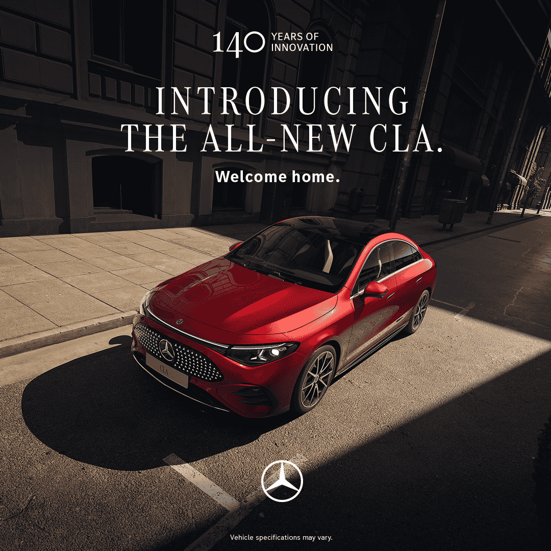 A red Mercedes-Benz CLA is parked on a city street under sunlight. Text reads Introducing the all-new CLA. Welcome home. Experience sophistication&mdash;drive with confidence, whether cruising downtown or heading out for an Amex-inspired night on the town. Mercedes-Benz logo is at the bottom.