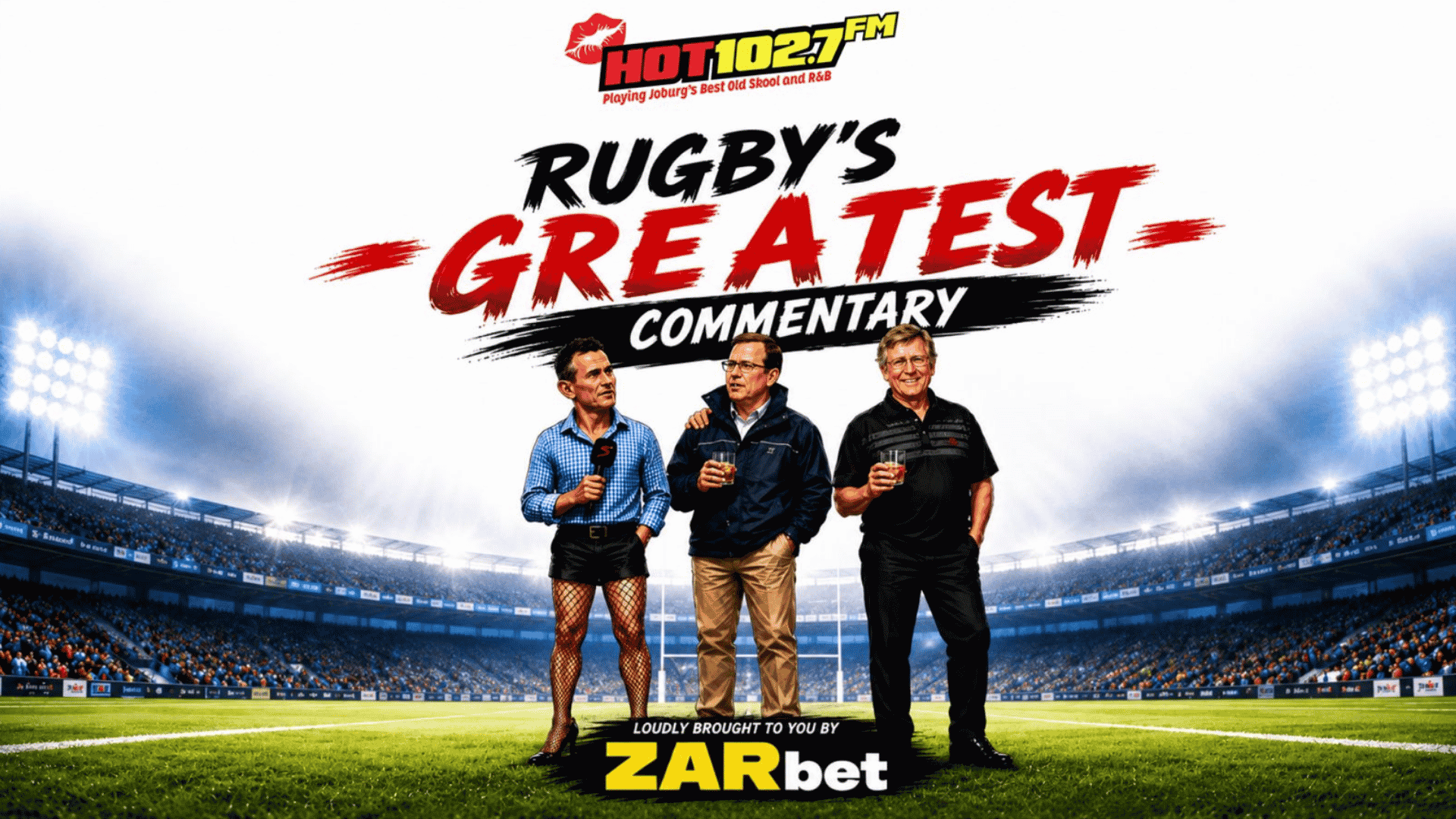 Three men stand on a rugby field holding drinks, wrapped warmly in winter blankets, with a stadium in the background. Text above them reads, Rugby’s Greatest Commentary, with HOT102.7FM and ZARbet logos also visible.