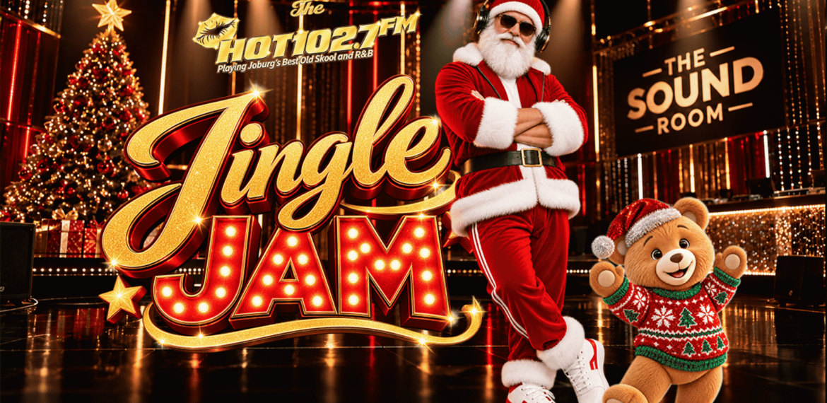 Santa Claus wearing headphones and a teddy bear in a festive sweater stand in a music studio in front of a Jingle Jam sign for Hot 102.7 FM.