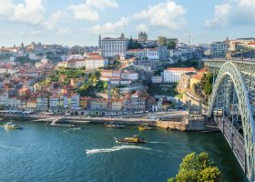 The colorful terraced buildings and Dom Lu&iacute;s I Bridge over the Douro River define this scenic Porto, Portugal cityscape for any travel destination.